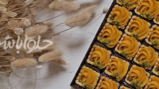 سینی «تارت بیسکویٔیتی ترحلوا زعفرانی با تزیٔینات پودر پسته»
